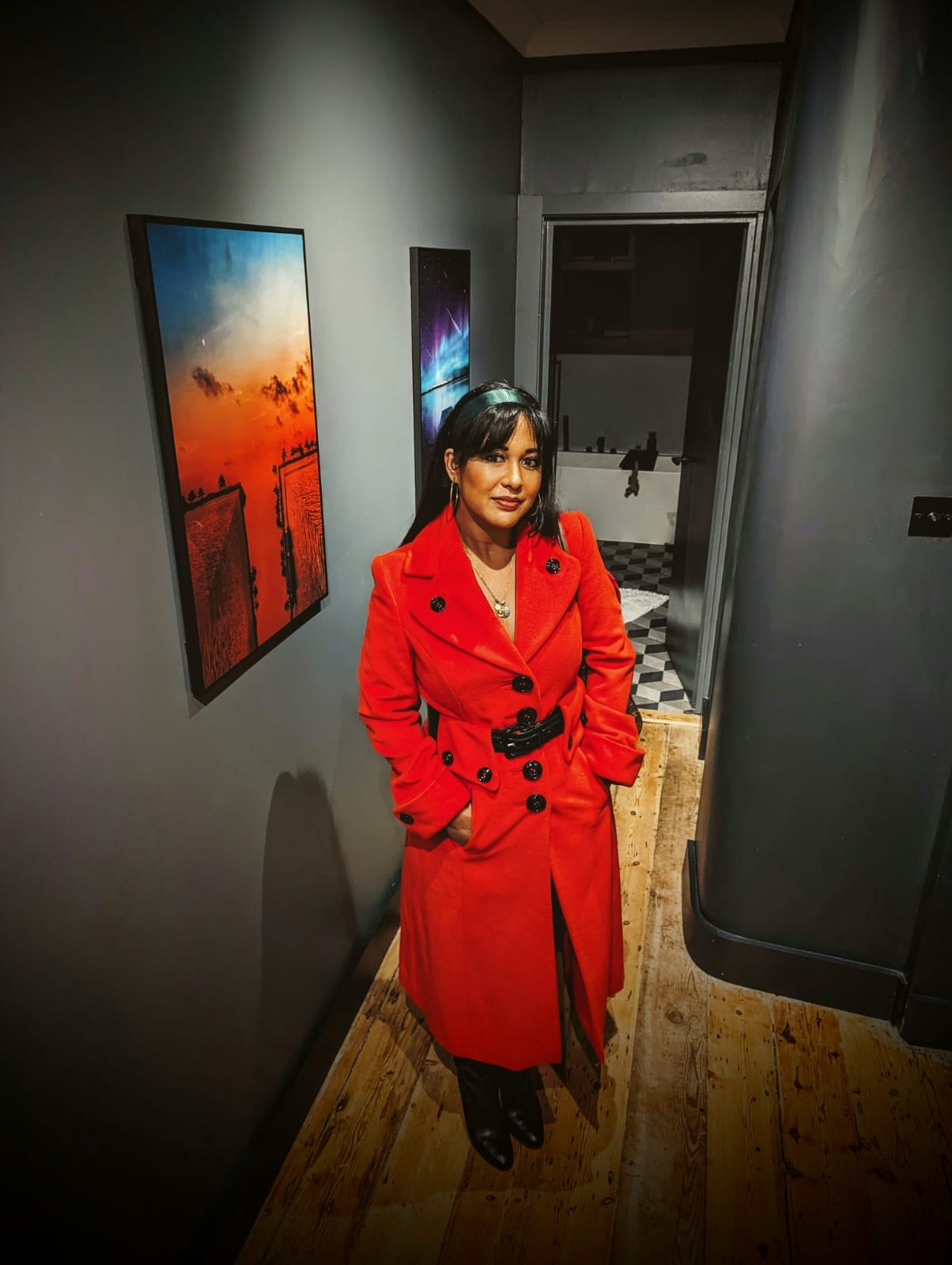 Camille seated at a club table in red dress